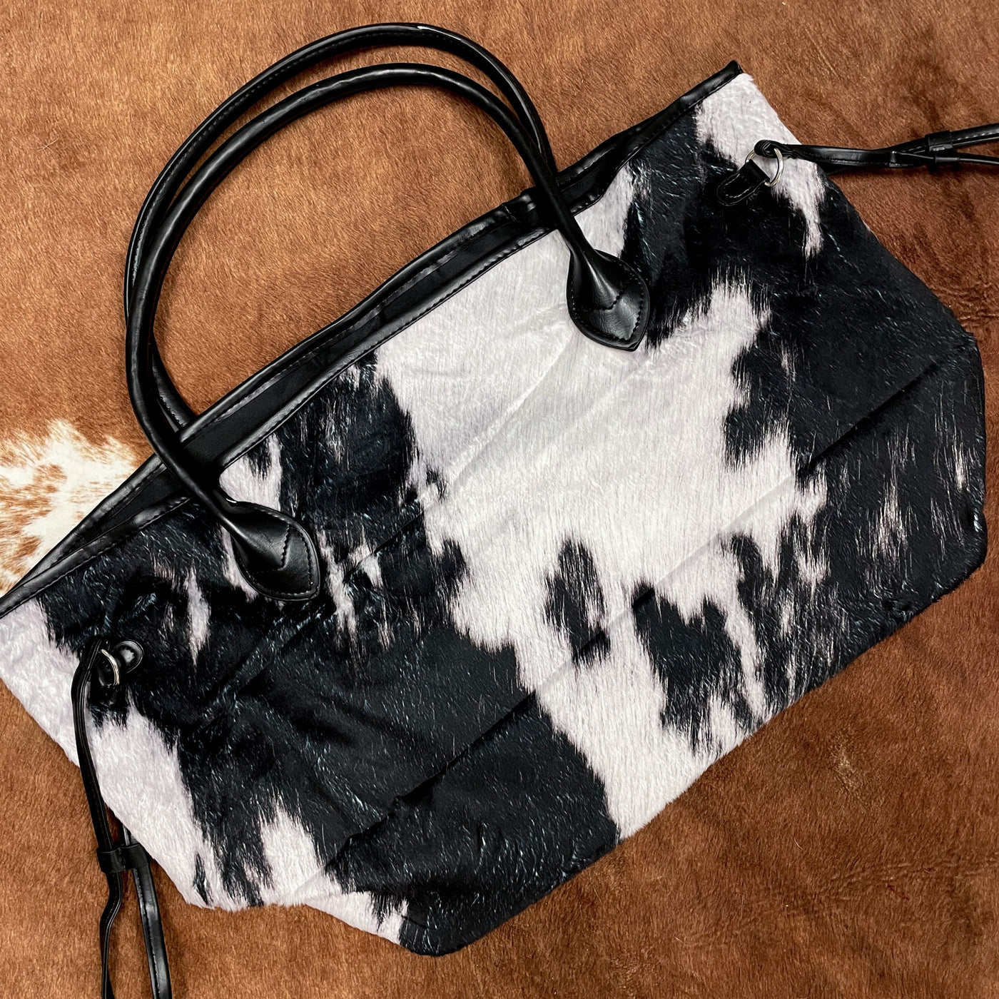Weekender tote bag a super soft, faux cowhide print - the perfect western-inspired gift for the traveler in your life! Choose from black or brown cow print.