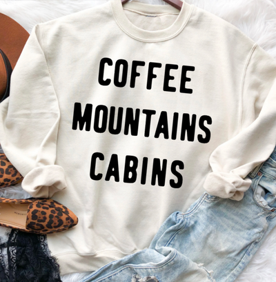 Super soft pullover sweatshirt featuring the words "Coffee Mountains Cabins." The perfect top for a mountain getaway. Design is available in black or white ink. Choose from sweatshirt or t-shirt.