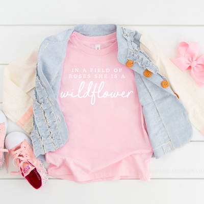Super soft infant bodysuit featuring the phrase "In a Field of Roses, She is a Wildflower." The perfect baby shower gift idea for mommy-to-be, Mother's Day outfit, birthday party, or every day!